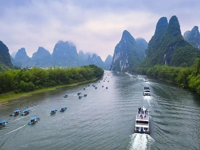 Aerial view of boats cruising on the Li River among karst mountains
