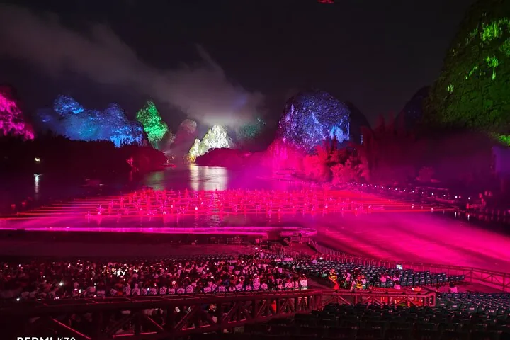 Espectáculo nocturno Impresión Sanjie Liu con montañas kársticas iluminadas y balsas