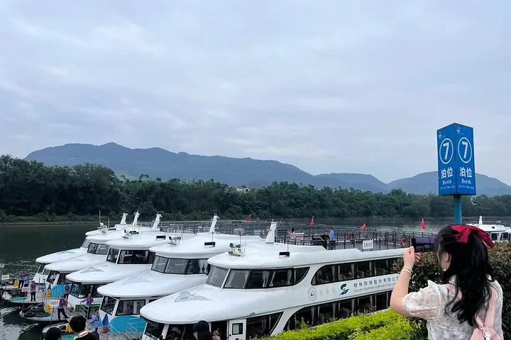 Turista tomando una foto de los barcos de crucero atracados en un muelle