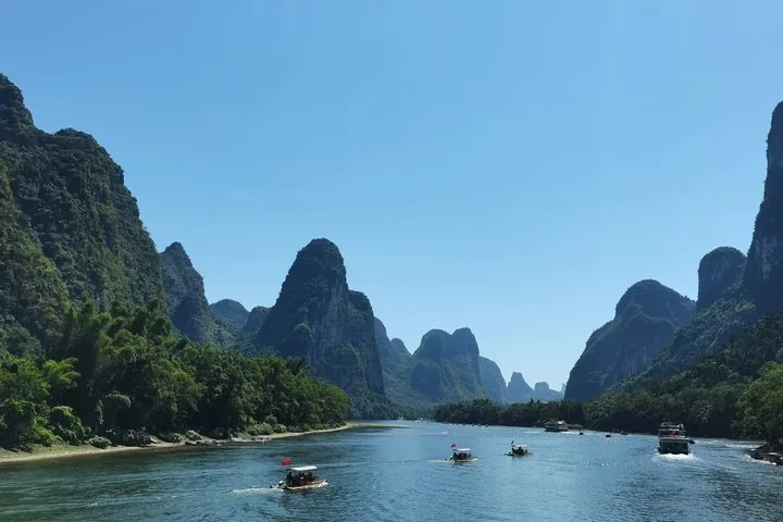 Barcos pequeños y cruceros en el río Li rodeados de picos espectaculares