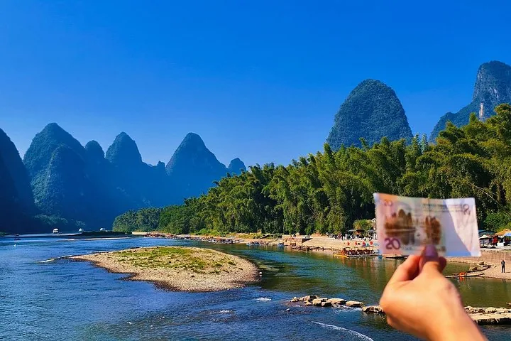 Person holding a 20 RMB note matching the Li River landscape behind