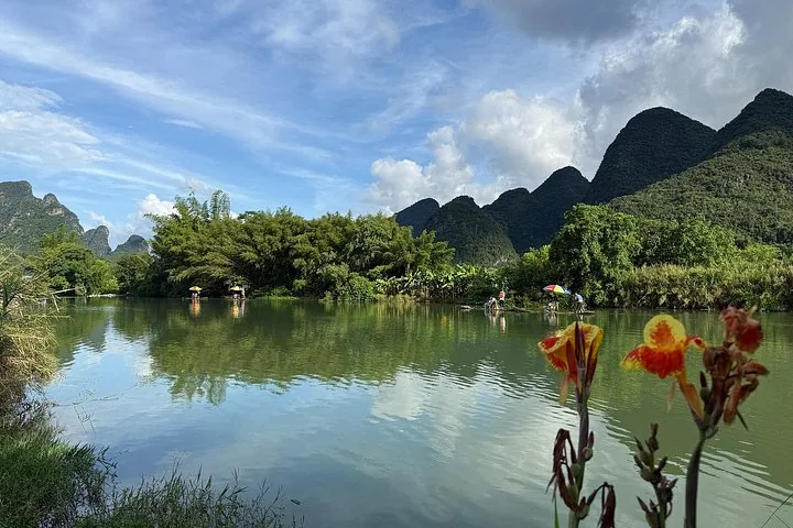 Ruhige Szene mit Bambusflößen auf dem Li-Fluss und Blumen im Vordergrund